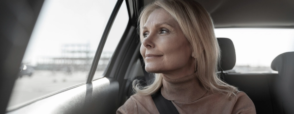 Woman inside car sightseeing during her airport transfer